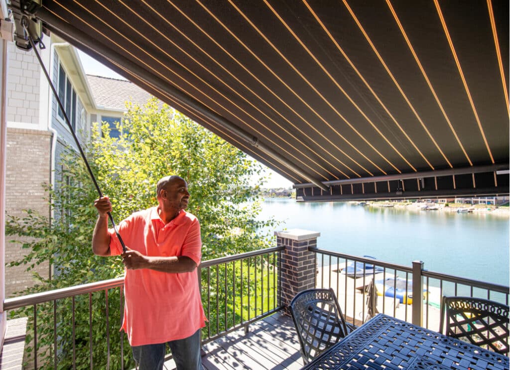 Smiling man demonstrating adjustable pitch on awning