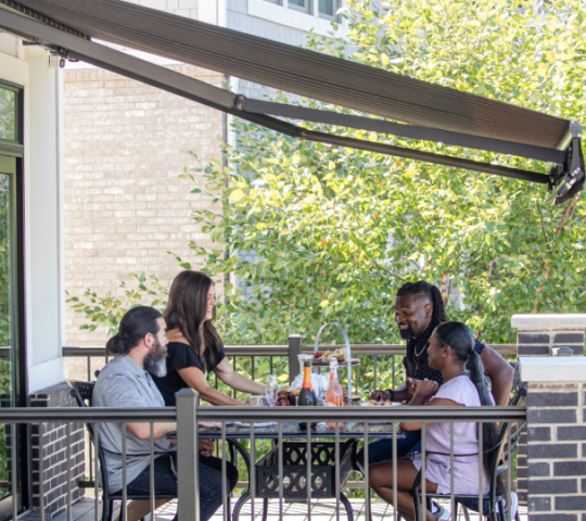 family underneath an awning on balcony