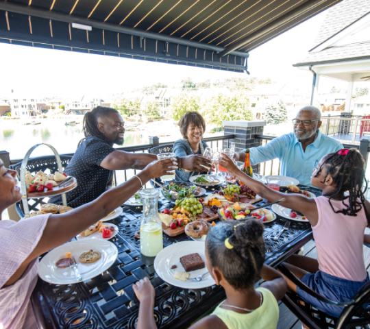 family toasting underneath a retractable awning