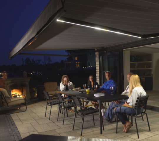 people enjoying drinks underneath an awning with LED lights at night
