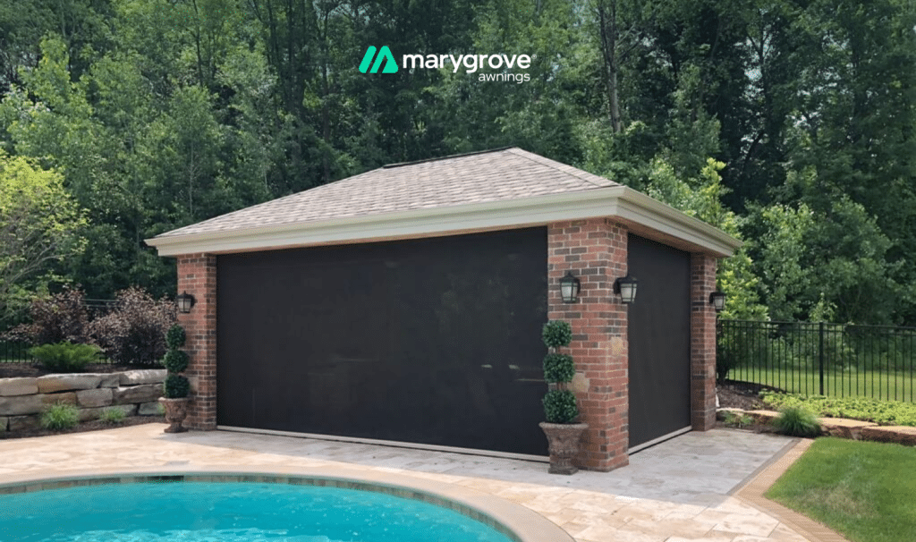 Retractable solar screens enclosing a brick poolside pavilion with a Marygrove Awnings logo above.