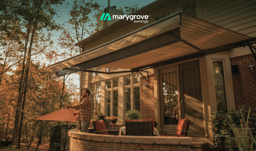 Marygrove retractable awning extended over a raised backyard patio with outdoor seating as a homeowner enjoys the warm evening sunlight.